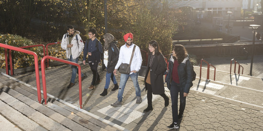 International students run up the stairs together.