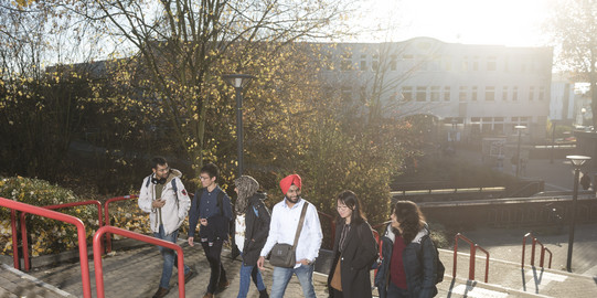 Internationale Studierende laufen zusammen die Treppe hoch.