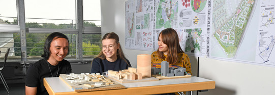 Students sit in front of building models.