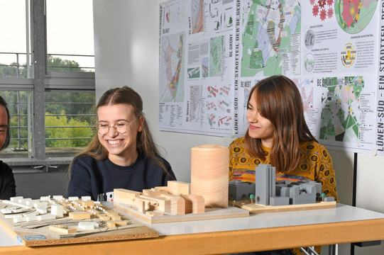 Students sit in front of building models.
