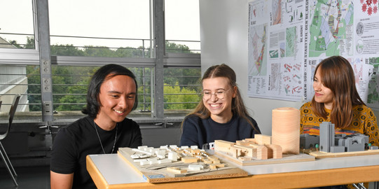 Students sit in front of building models.