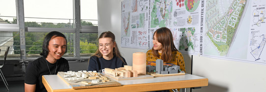 Titelbild Studierende Modelle Studierende sitzen vor Baumodellen.