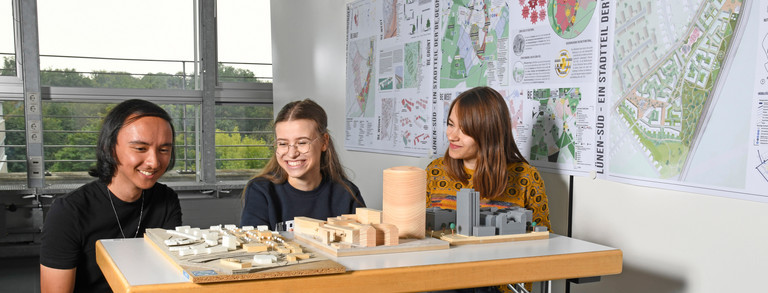 Students sit in front of building models.