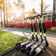 Öffentliche Verkehrsmittel (Modul 21) Im Hintergrund fährt eine Straßenbahn und im Vordergrund sind E-Scooter platziert.