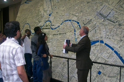The students listening to a speech in front of a model of Berlin