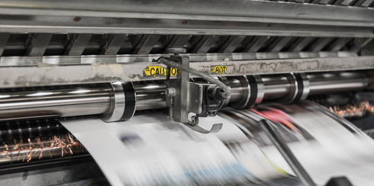 Druckerpresse wirft bedrucktes Papier heraus.