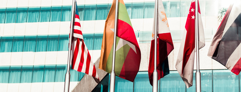 Flags Five flags of countries hang side by side on a pole.