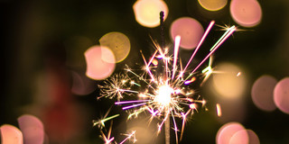 Silvester Person hält Wunderkerze in der Hand.