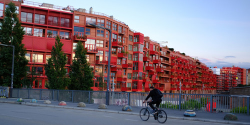 Straße mit Fahrradfahrer vor roten Häusern