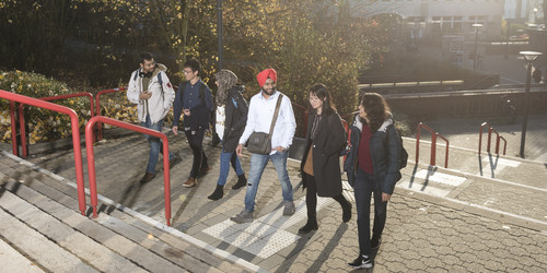 International students run up a staircase.