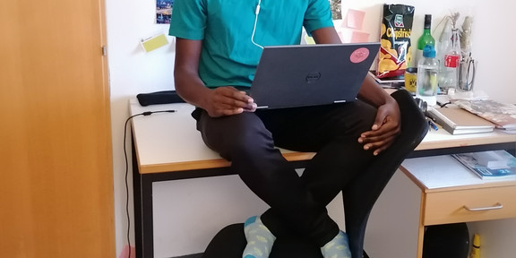 SPRING Online Teaching The picture shows Kabaka Mutensa studying at his desk.