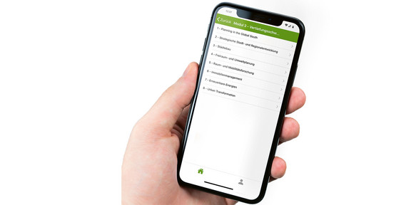 Master Seminarplatzvergabe Eine Hand hält ein Handy mit geöffneter TU App zur Buchung der Kurse.