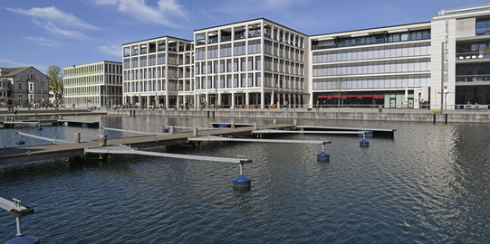 Phönixsee with water in the foreground and restaurant buildings in the background.