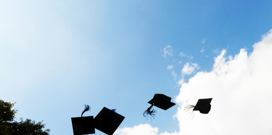 Four black academic hats