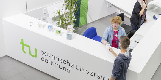 Ein Student gibt seine Wartenummer bei der Studienberatung ab.