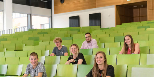 A group of students sit in the lecture hall.