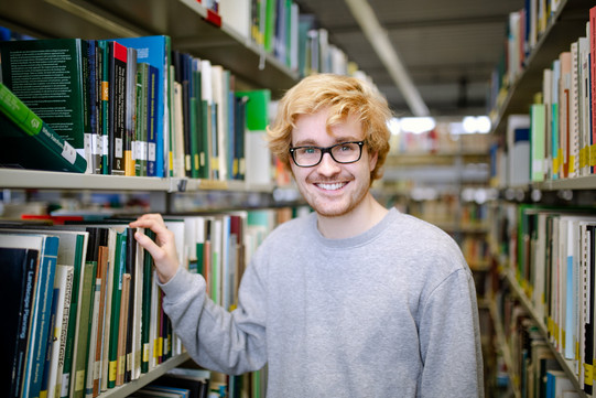 Students between bookshelves