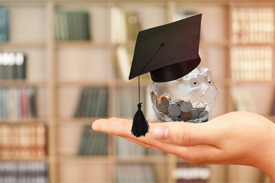A stuffed glass piggy bank with a doctoral hat
