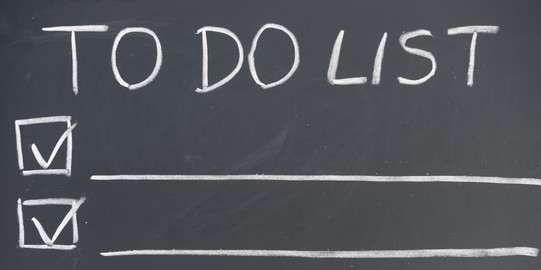 Liste mit Überschrift "To Do List", auf einer Tafel mit Kreide geschrieben.
